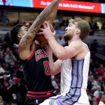 
              Chicago Bulls' Coby White (0) fouls Sacramento Kings' Domantas Sabonis during the first half of an NBA basketball game Wednesday, Feb. 16, 2022, in Chicago. (AP Photo/Charles Rex Arbogast)
            