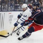 
              Toronto Maple Leafs' Morgan Rielly, left, and Columbus Blue Jackets' Oliver Bjorkstrand chase the puck during the second period of an NHL hockey game Tuesday, Feb. 22, 2022, in Columbus, Ohio. (AP Photo/Jay LaPrete)
            