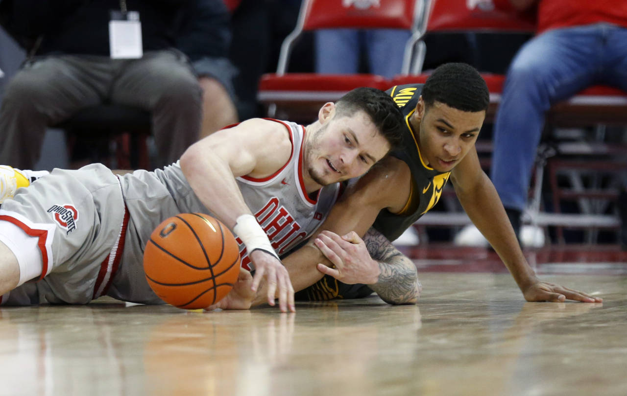 Ohio State forward Kyle Young, left, works for a loose ball against Iowa forward Keegan Murray duri...