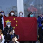 
              FILE - Spectators wait for Eileen Gu, of China, during the women's freestyle skiing big air finals of the 2022 Winter Olympics, Tuesday, Feb. 8, 2022, in Beijing. (AP Photo/Jae C. Hong, File)
            