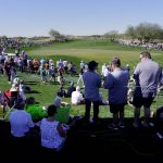 
              Fans circle the ninth hole as groups make their way up the fairway during the Phoenix Open golf tournament Thursday, Feb. 10, 2022, in Scottsdale, Ariz. (AP Photo/Darryl Webb)
            
