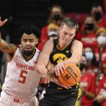 
              Iowa guard Payton Sandfort, right, and Maryland guard Eric Ayala (5) battle for the ball during the first half of an NCAA college basketball game, Thursday, Feb. 10, 2022, in College Park, Md. (AP Photo/Nick Wass)
            