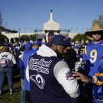 
              A fan admires the logo on a jacket from Super Bowl 34, which was won by the St. Louis Rams, during a gathering near Los Angeles Memorial Coliseum before the Los Angeles Rams' victory parade, Wednesday, Feb. 16, 2022, in Los Angeles, following the Rams' win Sunday over the Cincinnati Bengals in the NFL Super Bowl 56 football game. (AP Photo/Marcio Jose Sanchez)
            