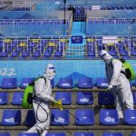 
              Workers in protective gear disinfect seats following the men's freestyle skiing big air finals of the 2022 Winter Olympics, Wednesday, Feb. 9, 2022, in Beijing. (AP Photo/Jae C. Hong)
            