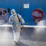 
              A worker wearing a protective suit sprays disinfectant outside an hotel at the 2022 Winter Olympics, Feb. 3, 2022, in Beijing. (AP Photo/Natacha Pisarenko)
            