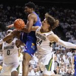 
              Kansas forward David McCormack, center, and Baylor guard Matthew Mayer try to get possession of the ball as Baylor forward Flo Thamba, left, watches during the first half of an NCAA college basketball game Saturday, Feb. 26, 2022, in Waco, Texas. (AP Photo/Ray Carlin)
            