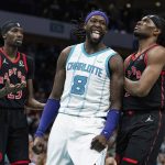 
              Charlotte Hornets center Montrezl Harrell (8) reacts after making a shot while guarded by Toronto Raptors forwards Chris Boucher (25) and Precious Achiuwa (5) during the first half of an NBA basketball game in Charlotte, N.C., Friday, Feb. 25, 2022. (AP Photo/Jacob Kupferman)
            
