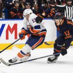 
              New York Islanders' Mathew Barzal (13) and Edmonton Oilers' Jesse Puljujarvi (13) compete for the puck during the first period of an NHL hockey game Friday, Feb. 11, 2022, in Edmonton, Alberta. (Jason Franson/The Canadian Press via AP)
            