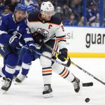 
              Tampa Bay Lightning defenseman Ryan McDonagh (27) and Edmonton Oilers center Connor McDavid (97) collide chasing a loose puck during the first period of an NHL hockey game Wednesday, Feb. 23, 2022, in Tampa, Fla. (AP Photo/Chris O'Meara)
            