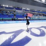 
              Erin Jackson of the United States carries an American flag across the ice after winning the gold medal in the speedskating women's 500-meter race at the 2022 Winter Olympics, Sunday, Feb. 13, 2022, in Beijing. (AP Photo/Ashley Landis)
            