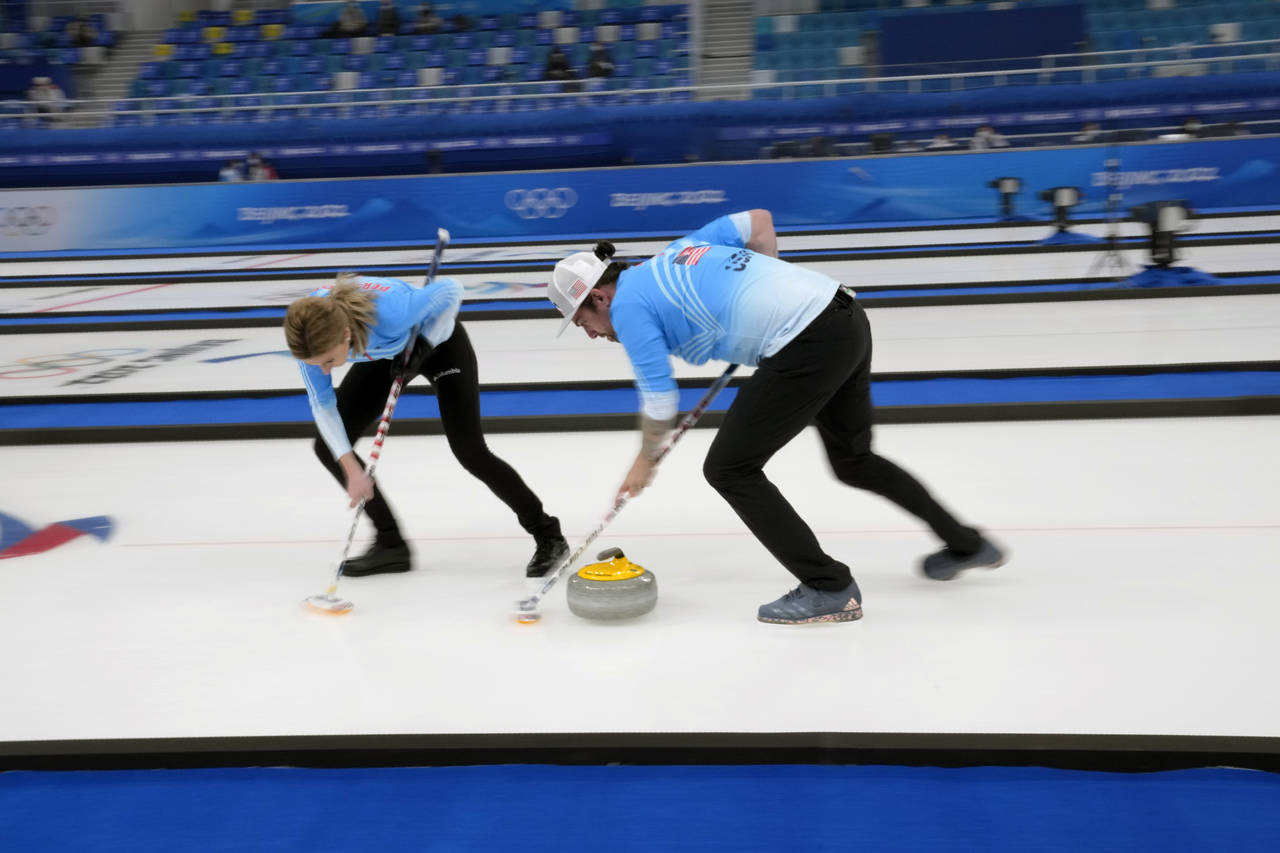 United States' Christopher Plys, and Victoria Persinger, sweep the ice, during the mixed doubles cu...