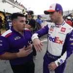 
              Denny Hamlin, right, talks to a crew member during a NASCAR Daytona 500 auto race practice at Daytona International Speedway, Friday, Feb. 18, 2022, in Daytona Beach, Fla. (AP Photo/John Raoux)
            