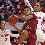 
              Florida State's O'Mariah Gordon (11) drives the ball between North Carolina State's Raina Perez (2) and Camille Hobby during the first half of an NCAA college basketball game Thursday, Feb. 3, 2022, in Raleigh, N.C. (AP Photo/Karl B. DeBlaker)
            