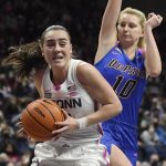 
              Connecticut's Nika Mühl, left, drives to the basket as DePaul's Lexi Held (10) defends in the second half of an NCAA college basketball game, Friday, Feb. 11, 2022, in Storrs, Conn. (AP Photo/Jessica Hill)
            