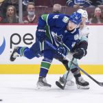 
              Vancouver Canucks' Elias Pettersson, front left, of Sweden, and Seattle Kraken's Yanni Gourde vie for the puck during the first period of an NHL hockey game in Vancouver, British Columbia, Monday, Feb. 21, 2022. (Darryl Dyck/The Canadian Press via AP)
            