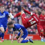 
              Liverpool's Jordan Henderson is updended in a challenge from Cardiff City's Mark Harris during the FA Cup fourth round soccer match between Liverpool and Cardiff City at Anfield stadium in Liverpool, England, Sunday, Feb. 6, 2022. (AP Photo/Jon Super)
            