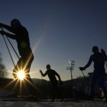 
              Biathletes train as the sun sets during a biathlon training session during the 2022 Winter Olympics, in Zhangjiakou, China, Monday, Feb. 14, 2022. (AP Photo/Kirsty Wigglesworth)
            
