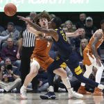 
              Texas guard Devin Askew (5) and West Virginia guard Kedrian Johnson (0) vie for the ball during the first half of an NCAA college basketball game in Morgantown, W.Va., Saturday, Feb. 26, 2022. (AP Photo/Kathleen Batten)
            