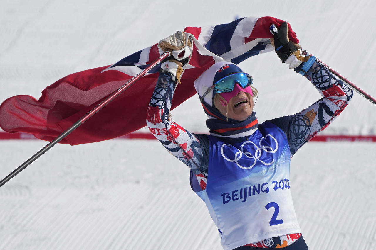 Norway's Therese Johaug celebrates after crossing the finish during the women's 30km mass start fre...