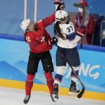 
              Switzerland's Sinja Leemann (22) and United States' Abbey Murphy (37) leap for the puck during a preliminary round women's hockey game at the 2022 Winter Olympics, Sunday, Feb. 6, 2022, in Beijing. (AP Photo/Petr David Josek)
            