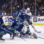 
              The puck deflects up above the net as Vancouver Canucks goalie Thatcher Demko (35) makes a save, Toronto Maple Leafs' Timothy Liljegren (37), of Sweden, watches and Canucks' Brad Hunt (77), Vasily Podkolzin (92), of Russia, and Luke Schenn (2) defend during the first period of an NHL hockey game in Vancouver, British Columbia, Saturday, Feb. 12, 2022. (Darryl Dyck/The Canadian Press via AP)
            