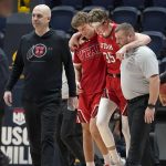
              Utah coach Craig Smith, left, walks toward the bench as center Branden Carlson, middle, is helped off the court during the second half of the team's NCAA college basketball game against California in Berkeley, Calif., Saturday, Feb. 19, 2022. (AP Photo/Jeff Chiu)
            