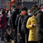 
              Residents wearing face masks to help protect from the coronavirus line up outside a COVID-19 test site in Beijing, Tuesday, Feb. 8, 2022. China has ordered inhabitants of the southern city of Baise to stay home and suspended transportation links amid a surge in COVID-19 cases at least partly linked to the omicron variant. (AP Photo/Andy Wong)
            