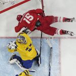 
              Russian Olympic Committee's Pavel Karnaukhov (15) collides with Sweden goalkeeper Lars Johansson during overtime in a men's semifinal hockey game at the 2022 Winter Olympics, Friday, Feb. 18, 2022, in Beijing. (AP Photo/Matt Slocum)
            