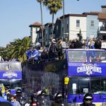 
              Buses carrying Los Angeles Rams players and coaches drive past fans during the team's victory parade in Los Angeles, Wednesday, Feb. 16, 2022, following their win Sunday over the Cincinnati Bengals in the NFL Super Bowl 56 football game. (AP Photo/Marcio Jose Sanchez)
            