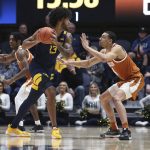 
              West Virginia forward Isaiah Cottrell (13) is defended by Texas forward Dylan Disu (4) during the first half of an NCAA college basketball game in Morgantown, W.Va., Saturday, Feb. 26, 2022. (AP Photo/Kathleen Batten)
            