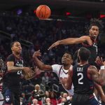 
              St. John's Montez Mathis, center, shoots between Connecticut defenders during the second half of an NCAA college basketball game Sunday, Feb. 13, 2022, in New York. (AP Photo/Seth Wenig)
            