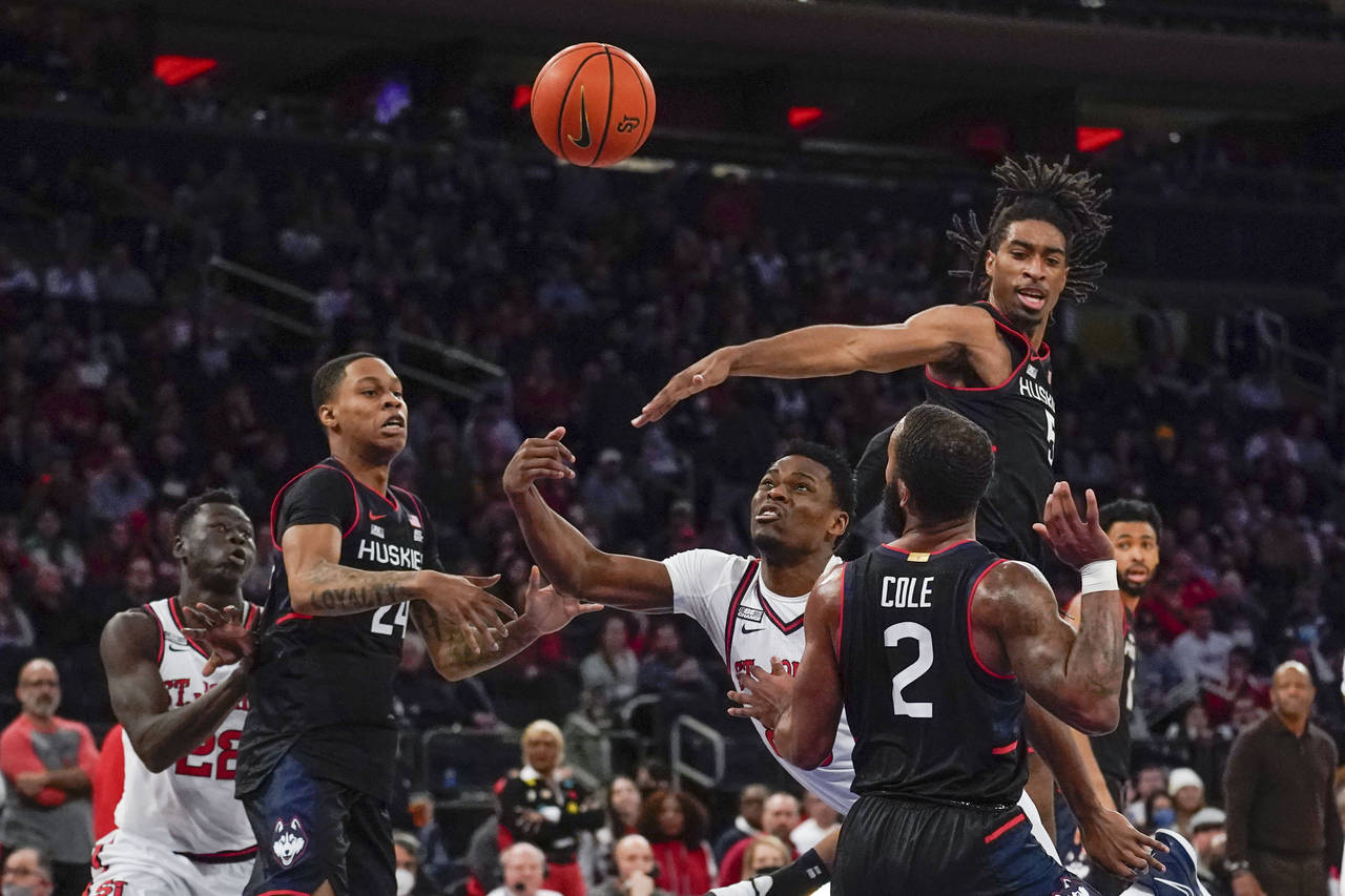 St. John's Montez Mathis, center, shoots between Connecticut defenders during the second half of an...