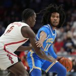 
              UCLA guard Tyger Campbell shields the ball from Arizona guard Bennedict Mathurin (0) during the first half of an NCAA college basketball game Thursday, Feb. 3, 2022, in Tucson, Ariz. (AP Photo/Rick Scuteri)
            