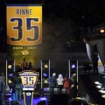 
              A banner with the number of former Nashville Predators goalie Pekka Rinne is raised during a ceremony before an NHL hockey game Thursday, Feb. 24, 2022, in Nashville, Tenn. Rinne's jersey number was retired after playing 15 seasons for the team. (AP Photo/Mark Humphrey)
            