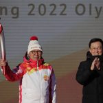 
              First Torch bearer Luo Zhihuan holds up the torch after receiving it from Chinese Vice Premier Han Zheng before the start of the torch relay for the 2022 Winter Olympics at the Olympic Forest Park in Beijing on Wednesday, Feb. 2, 2022. (AP Photo/Sam McNeil)
            