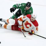 
              Dallas Stars defenseman Joel Hanley (44) and Calgary Flames center Adam Ruzicka (63) fall to the ice after colliding while chasing after a loose puck in the third period of an NHL hockey game in Dallas, Tuesday, Feb. 1, 2022. (AP Photo/Tony Gutierrez)
            