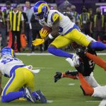 
              Los Angeles Rams wide receiver Brandon Powell, top, leaps over Cincinnati Bengals defenders during the second half of the NFL Super Bowl 56 football game Sunday, Feb. 13, 2022, in Inglewood, Calif. (AP Photo/Mark J. Terrill)
            