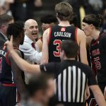 
              Utah head coach Craig Smith, center, confers with players late in the second half of an NCAA college basketball game against Colorado, Saturday, Feb. 12, 2022, in Boulder, Colo. (AP Photo/David Zalubowski)
            