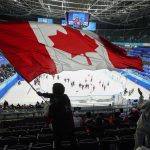 
              A fan waves a Canadian flag following a men's qualification round hockey game between Canada and China at the 2022 Winter Olympics, Tuesday, Feb. 15, 2022, in Beijing. Canada won 7-2. (AP Photo/Mark Humphrey)
            