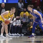 
              West Virginia guard Sean McNeil (22) is defended by Kansas guard Christian Braun (2) during the first half of an NCAA college basketball game in Morgantown, W.Va., Saturday, Feb. 19, 2022. (AP Photo/Kathleen Batten)
            