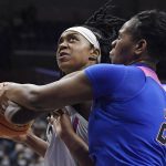 
              Connecticut's Christyn Williams is fouled by DePaul's Darrione Rogers (21) during the second half of an NCAA college basketball game Friday, Feb. 11, 2022, in Storrs, Conn. (AP Photo/Jessica Hill)
            