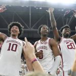 
              Arkansas players, from left, Jaylin Williams, Stanley Umude and Kamani Johnson celebrate after defeating Auburn 80-76 in overtime following an NCAA college basketball game Tuesday, Feb. 8, 2022, in Fayetteville, Ark. (AP Photo/Michael Woods)
            