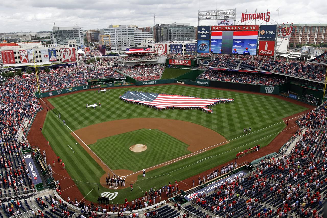 FILE - This July 4, 2013, file photo shows a U.S. flag, in the shape of the country, in the outfiel...