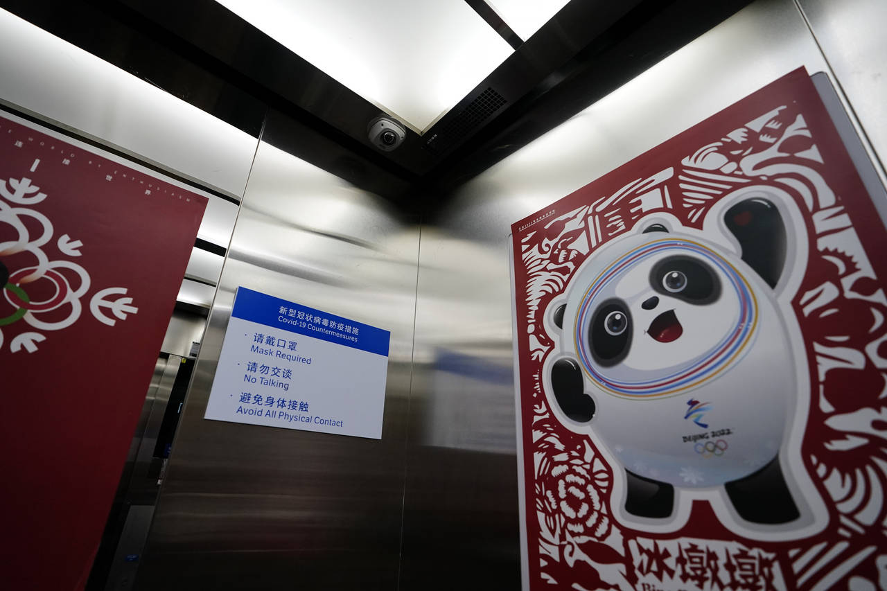 Inside an elevator shows a poster of Bing Dwen Dwen, the Beijing Winter Olympics mascot and a camer...