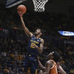 
              West Virginia guard Taz Sherman (12) shoots while defended by Texas guard Marcus Carr (2) during the second half of an NCAA college basketball game in Morgantown, W.Va., Saturday, Feb. 26, 2022. (AP Photo/Kathleen Batten)
            