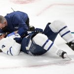 
              Toronto Maple Leafs' Jake Muzzin lies on the ice after a collision with a player from the Montreal Canadiens during second-period NHL hockey game action in Montreal, Monday, Feb. 21, 2022. (Graham Hughes/The Canadian Press via AP)
            