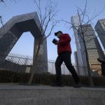 
              Residents walk past near the iconic Beijing headquarters of China Central TV in Beijing on Feb. 9, 2022. China has thousands of years of doing things in a really big way, reinforcing its perceived place in the world and the political power of its leaders — from emperors to Mao Zedong to Xi Jinping. None of this bigness is new. It goes back to a dozen dynasties that ruled China for thousands of years, a tradition of projecting power that was adopted by the Chinese Communist Party when it came to power in 1949. It could be termed simply: big, bigger and biggest — and then some. (AP Photo/Ng Han Guan)
            