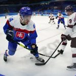 
              Slovakia's Mislav Rosandic (44) and Latvia's Renars Krastenbergs (9) play during a preliminary round men's hockey game at the 2022 Winter Olympics, Sunday, Feb. 13, 2022, in Beijing. (AP Photo/Matt Slocum)
            