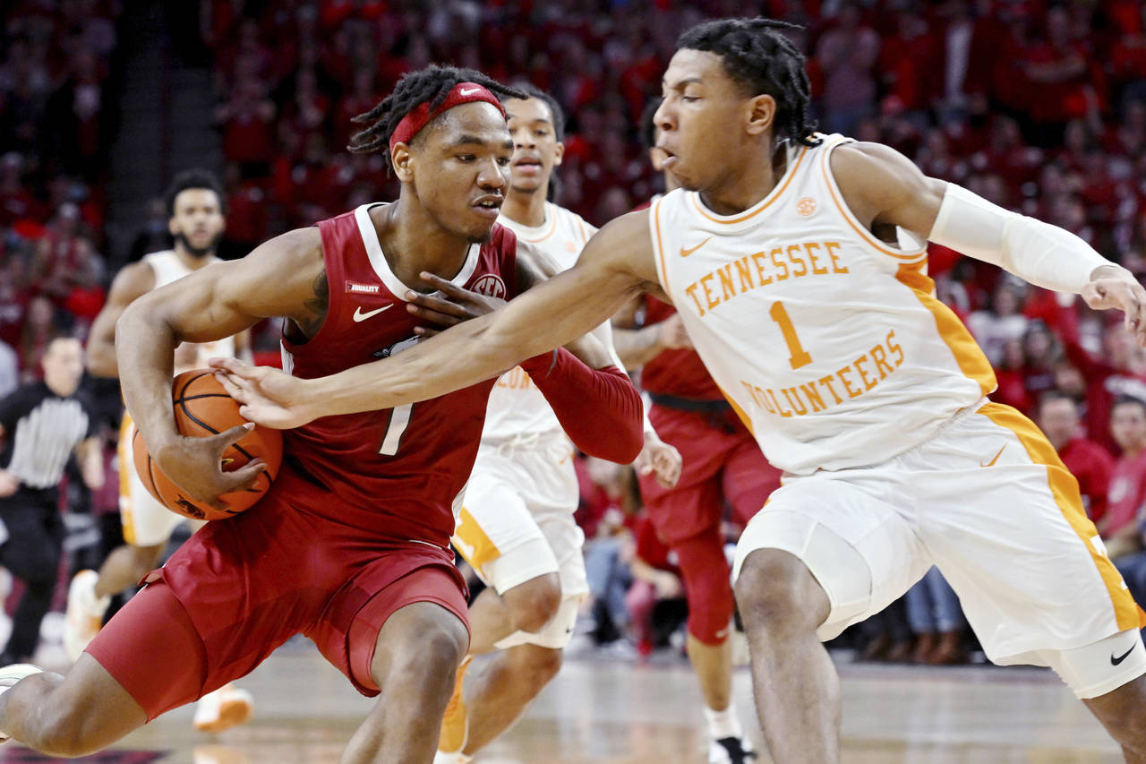 Arkansas guard JD Notae, left, tries to get past Tennessee guard Kennedy Chandler, right, during th...