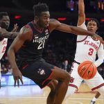 
              Connecticut's Adama Sanogo, center, tries to maintain control of the ball during the first half of an NCAA college basketball game against St. John's Sunday, Feb. 13, 2022, in New York. (AP Photo/Seth Wenig)
            